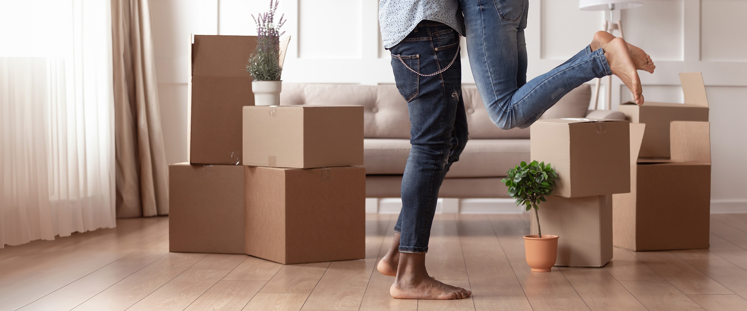 Photo showing the legs of a couple in an embrace their new home.