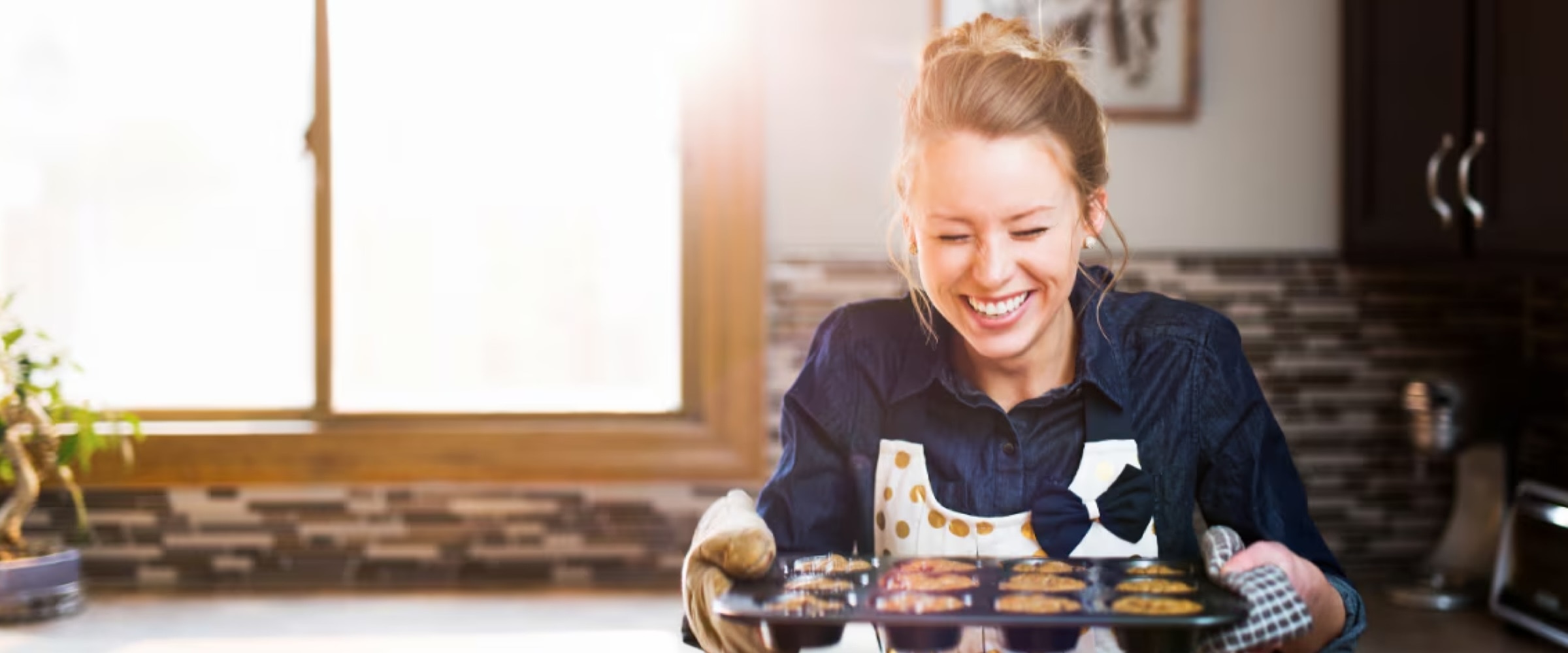 Photo of woman holding a tray of just baked cookies.