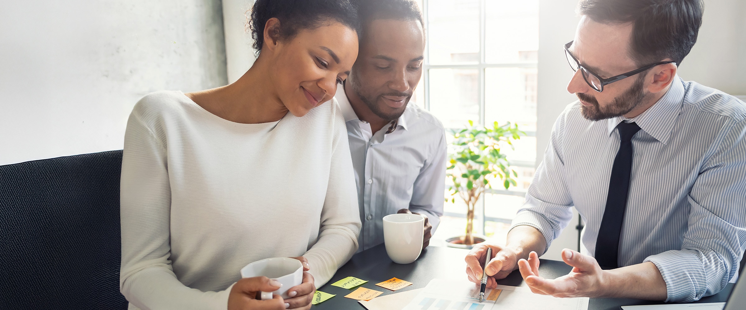 Photo of couple working with a tax professional at a desk.