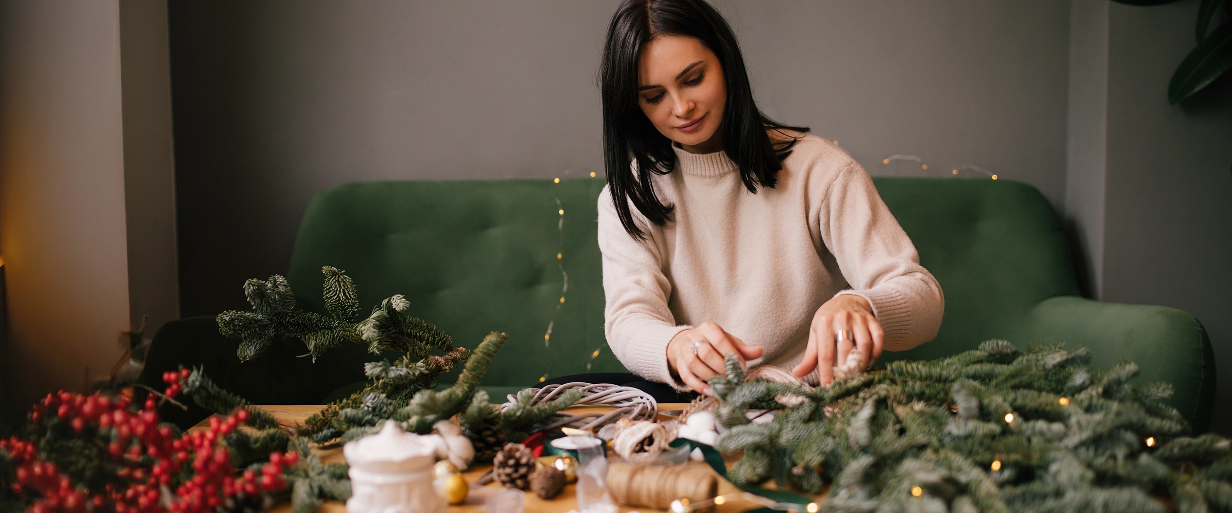 Photo of young woman wrapping gifts on coffee table.