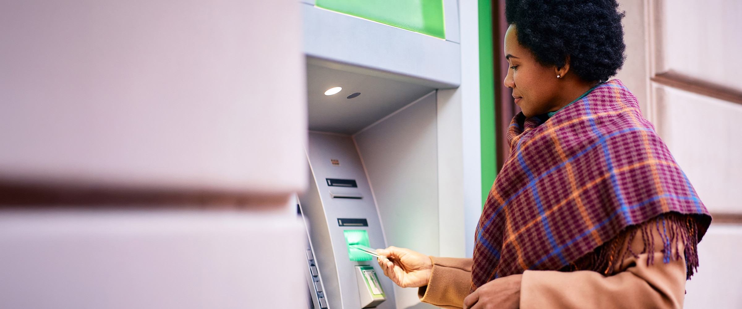 Image of woman interacting with a bank ATM machine.