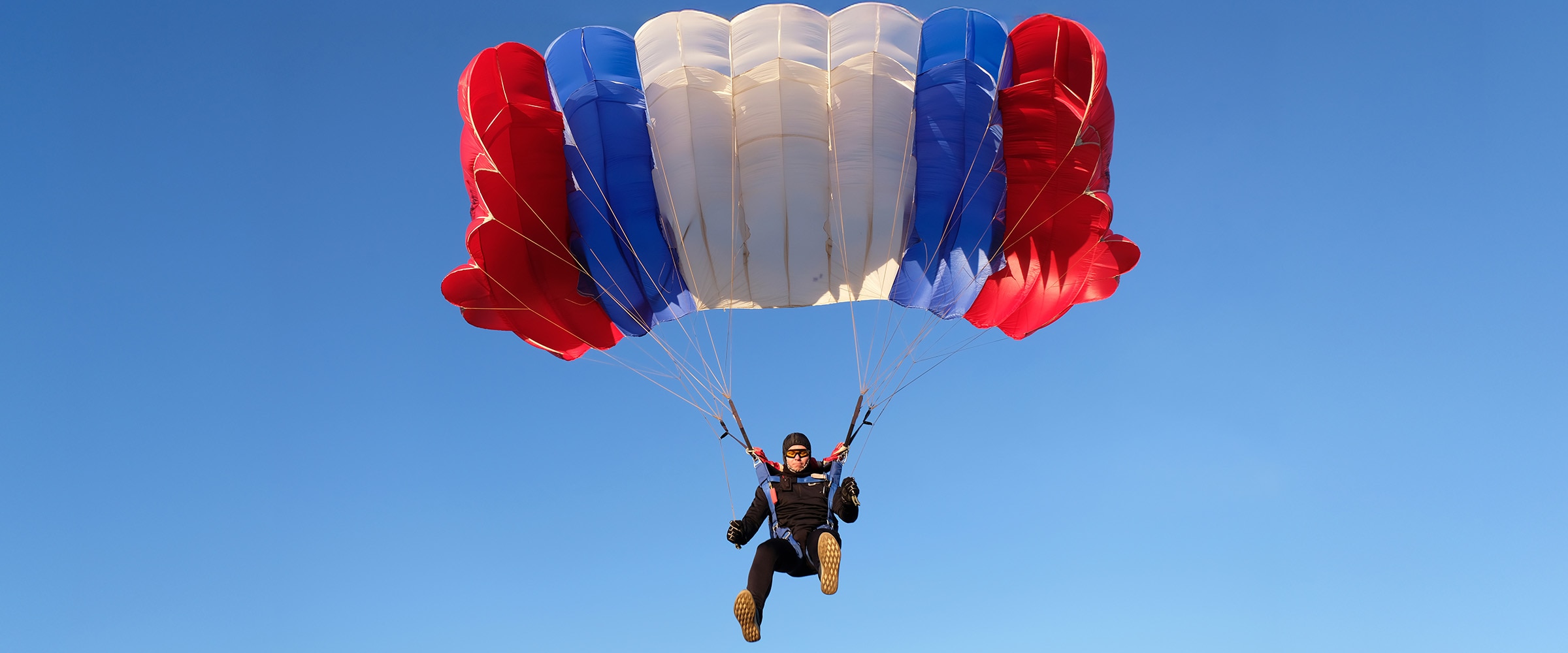 Photo of man using parachute in the air.