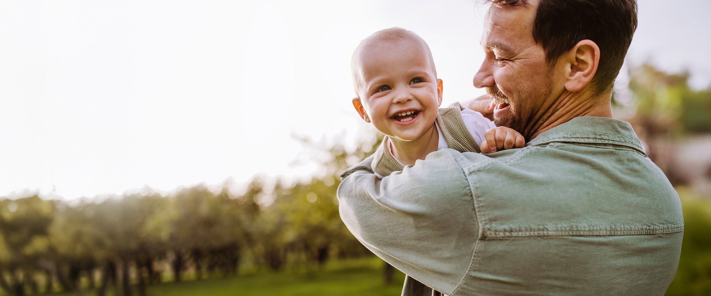 Photo of father lovingly holding a young child.