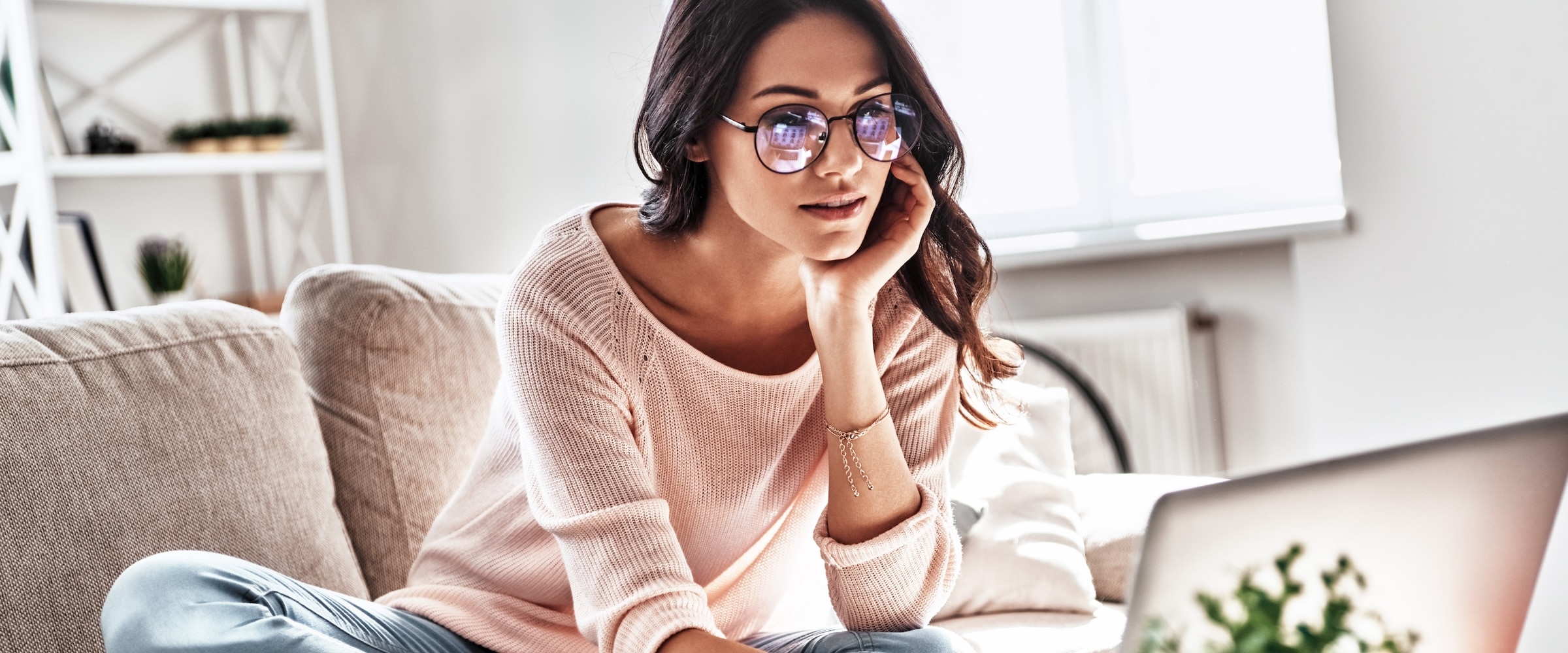 Woman looking at her laptop on couch.