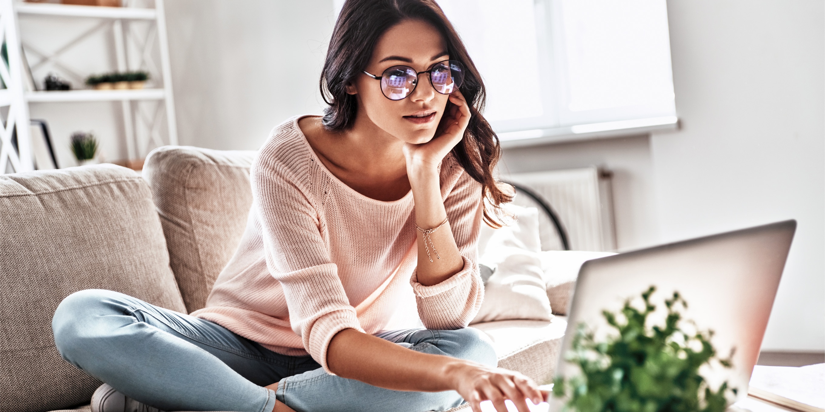 Photo of a woman on couch looking at her computer.