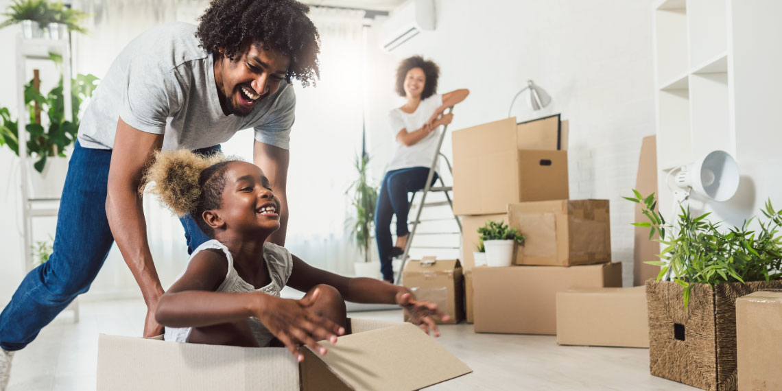 Photo of African American family in home with moving boxes.