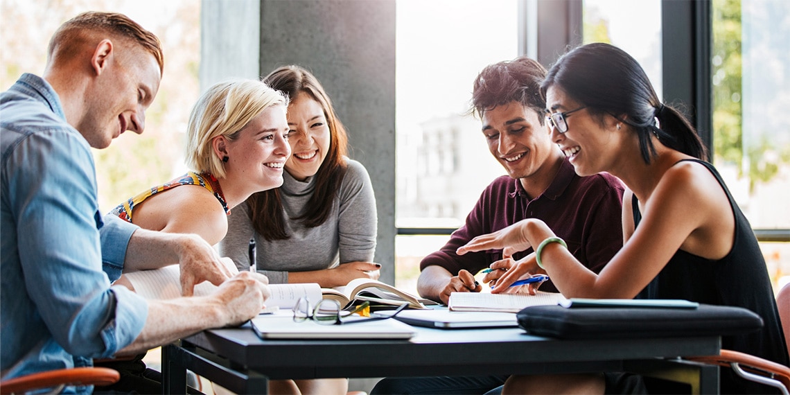 Photo of young college kids around a table.