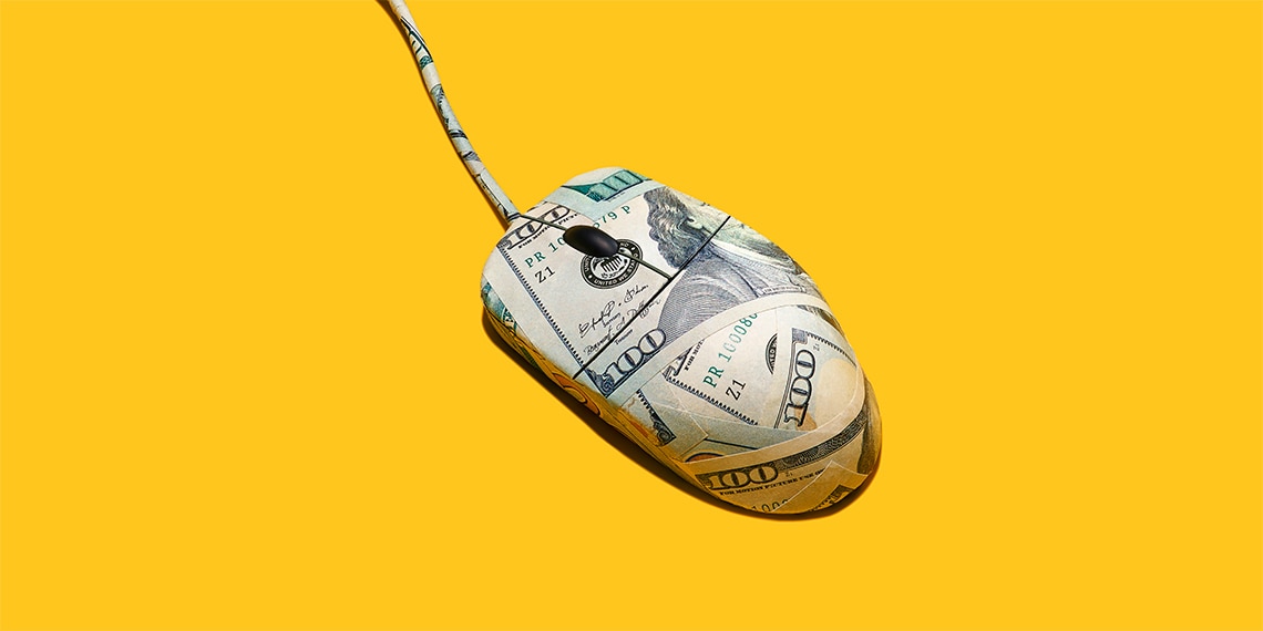 A computer mouse wrapped in hundred dollar bills