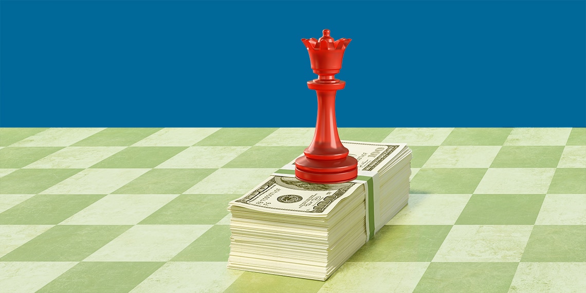 A queen chess piece on a stack of money