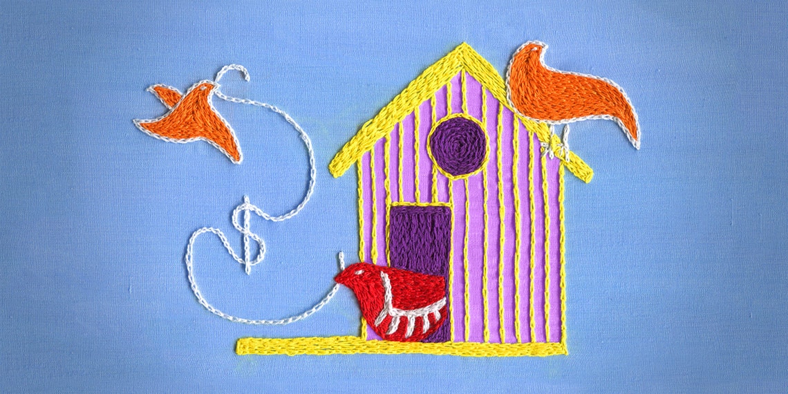 A needlepoint of a birdhouse with a bird flying away.