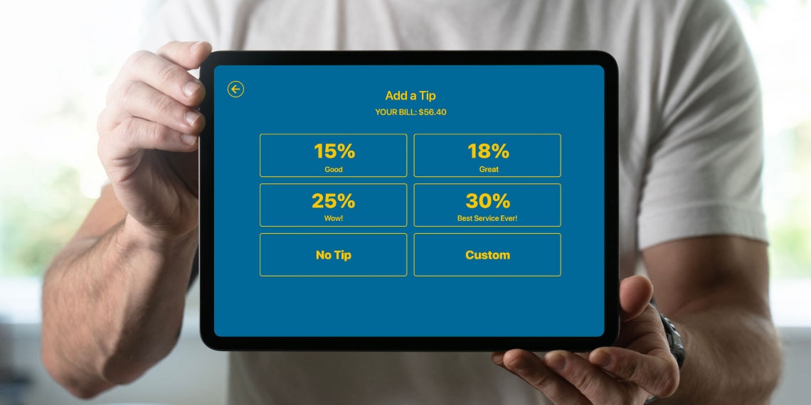 Photo of person holding up tablet showing different tipping options.