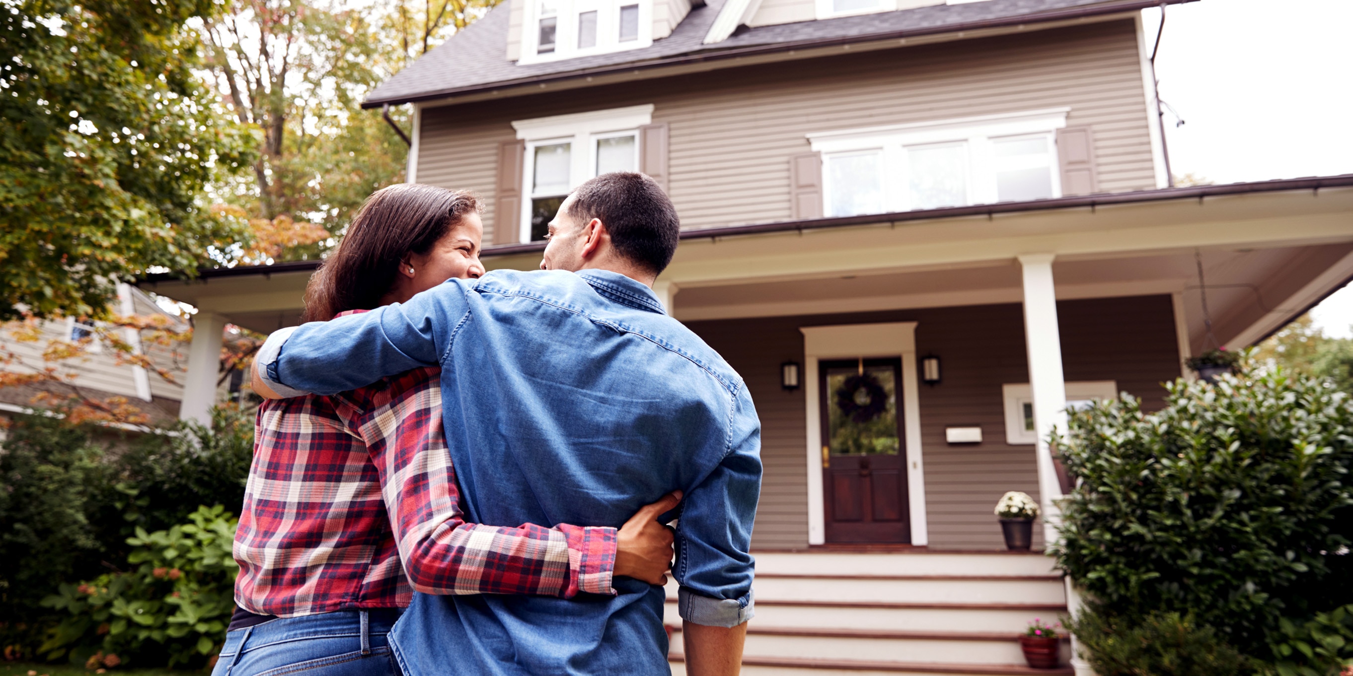 Photo of couple with arms around each other as they walk into home.