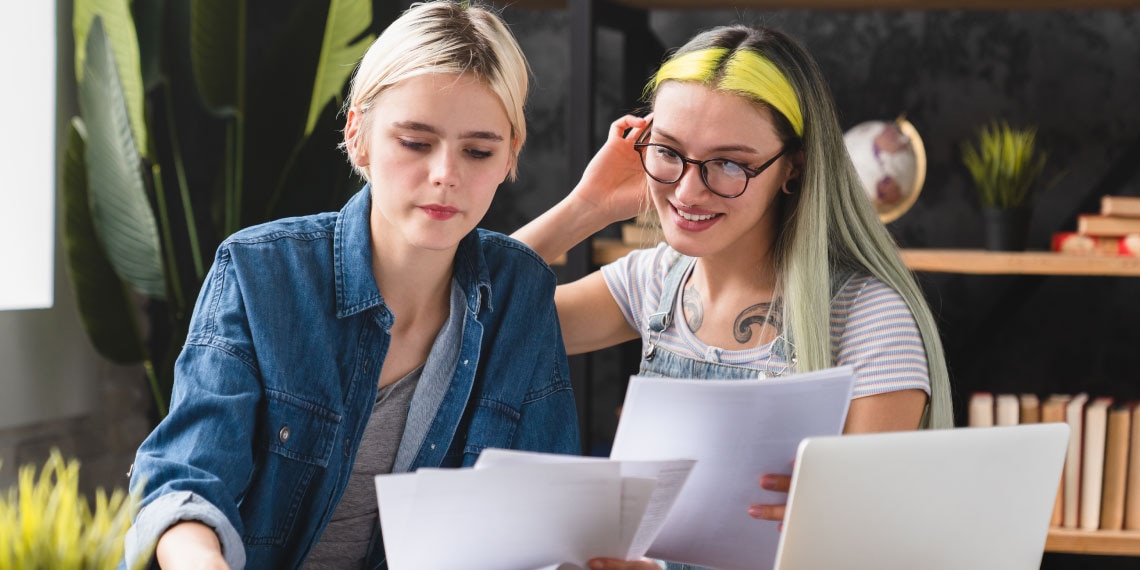 Photo of female couple looking over tax documents.