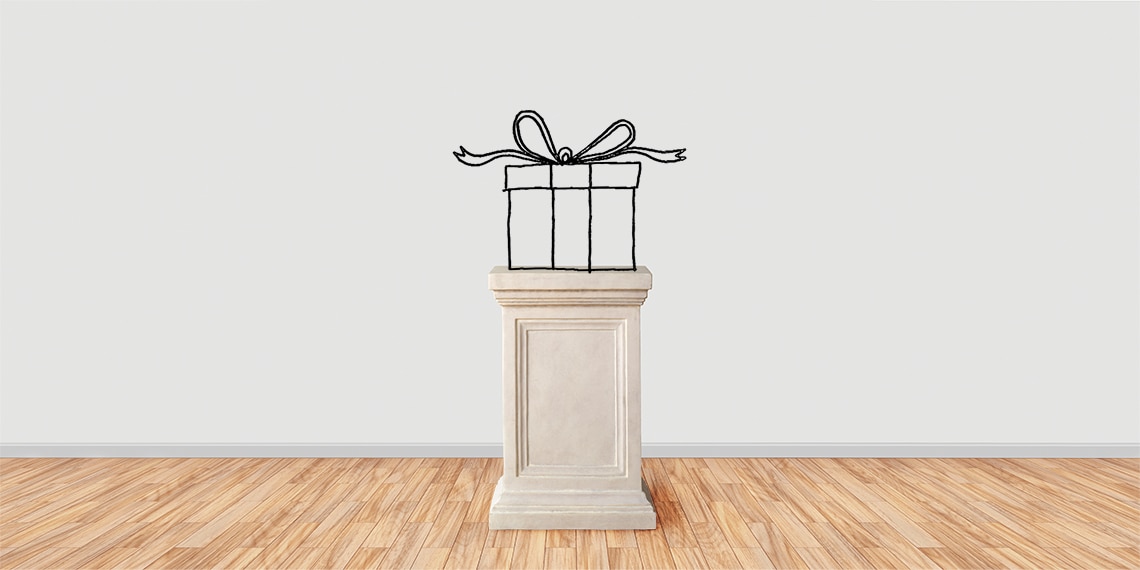 Photo of a pedestal with a line drawing of a wrapped gift on top.