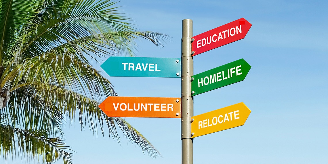 Colorful road signs showing different directions with titles like volunteer and travel.